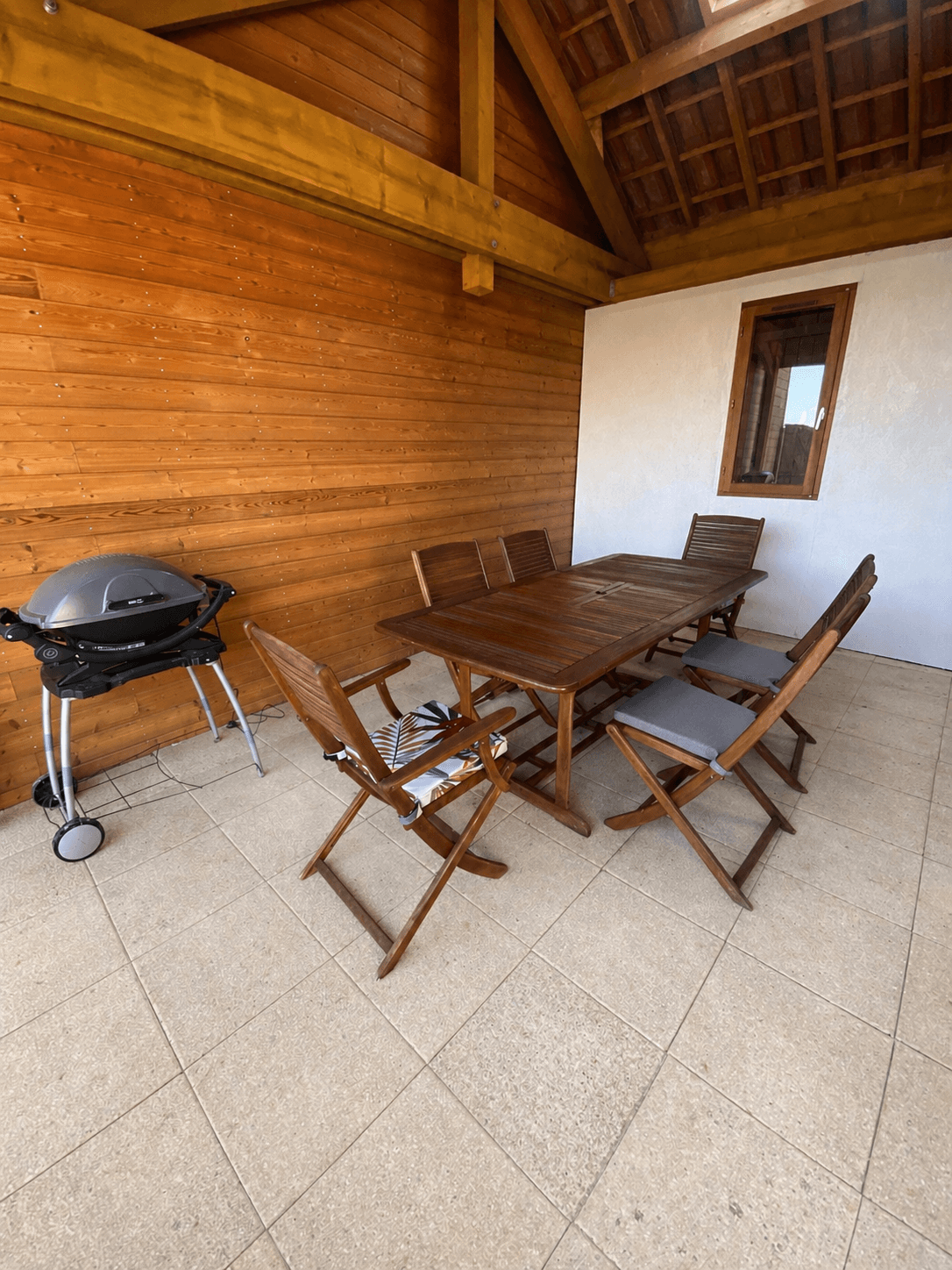 Terrasse couverte avec table de jardin et barbecue